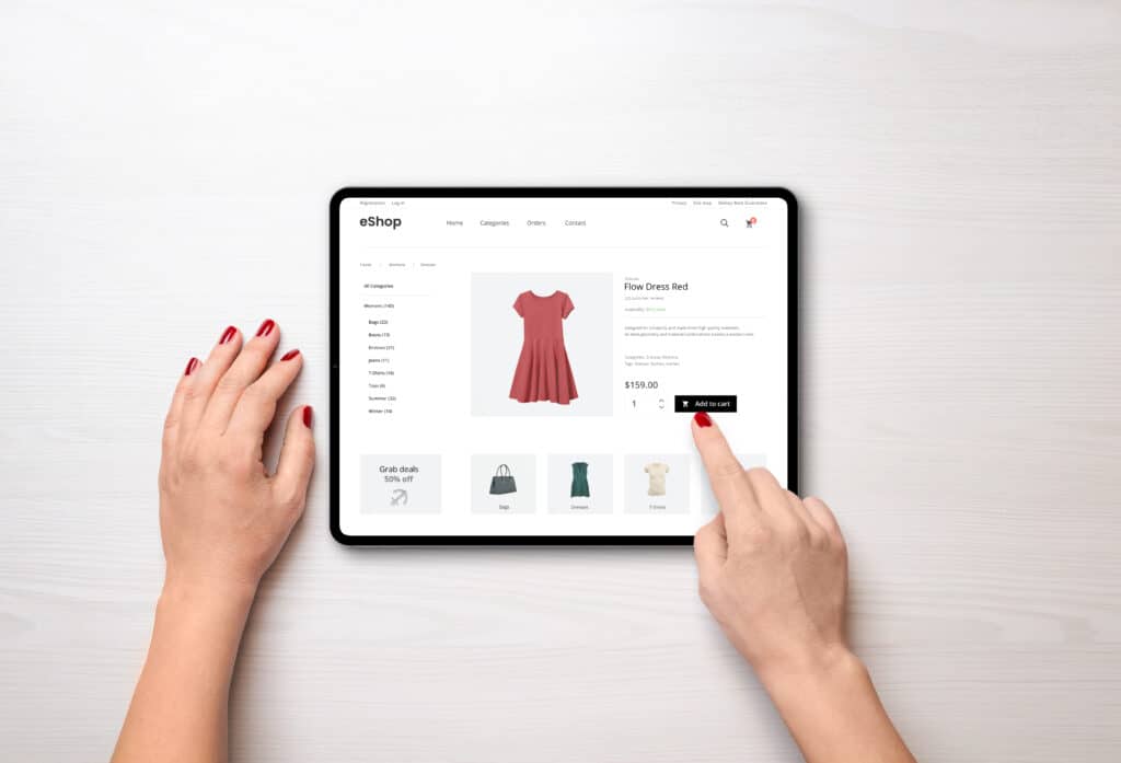 online shopping with a tablet. red women's dress on the e commerce web page