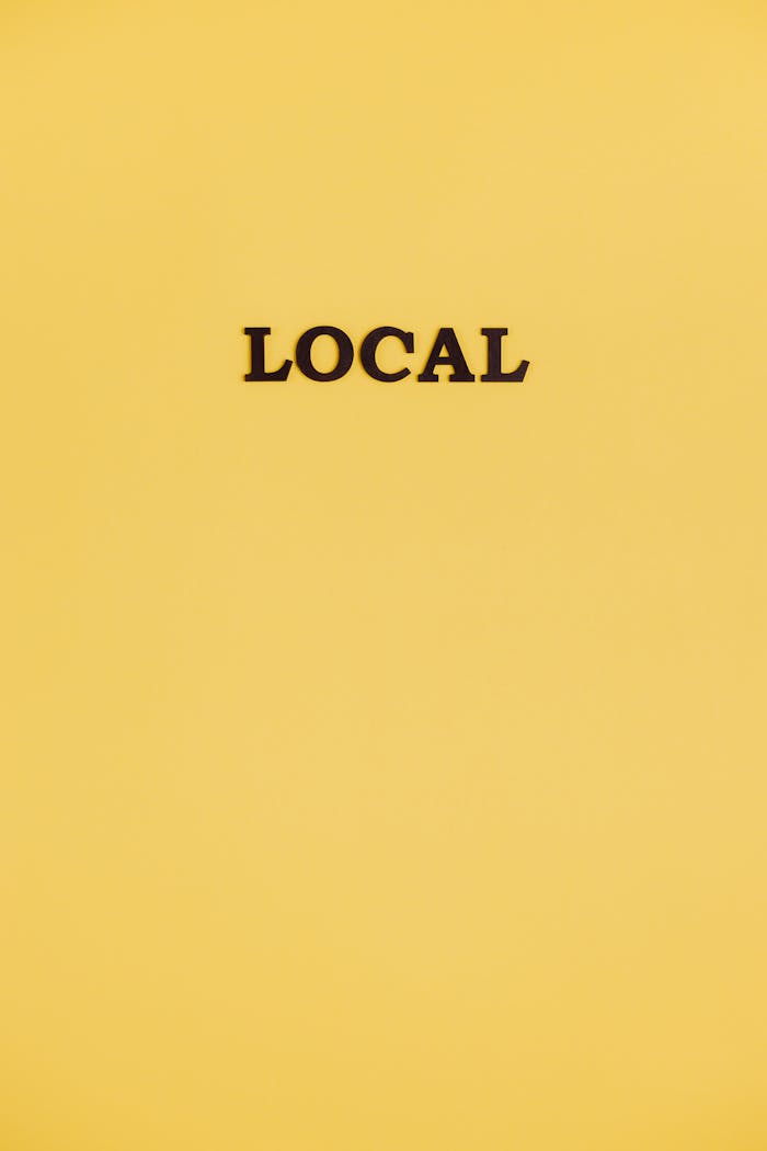 A simple yellow background with the word 'local' centered, offering ample copy space.
