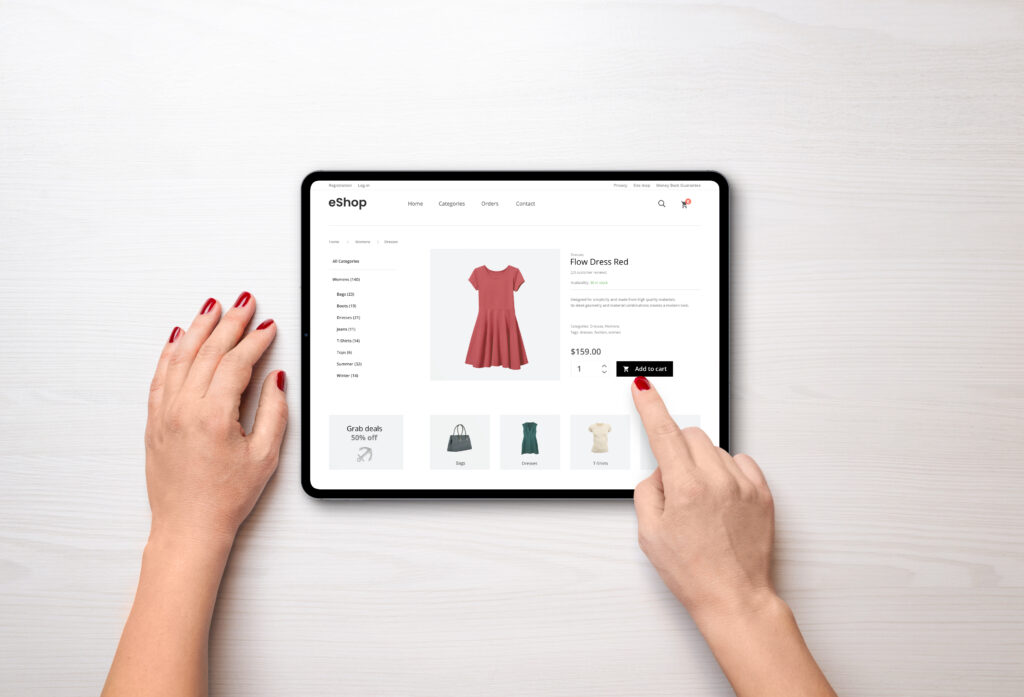 online shopping with a tablet. red women's dress on the e commerce web page online shopping with a tablet. red women's dress on the e commerce web page